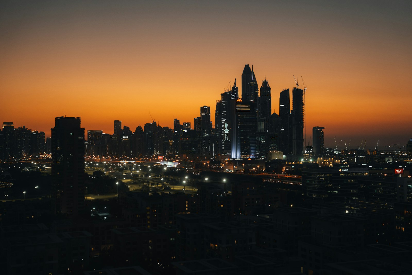 Dubai skyline at golden hour — modern glass business towers against a warm sky
