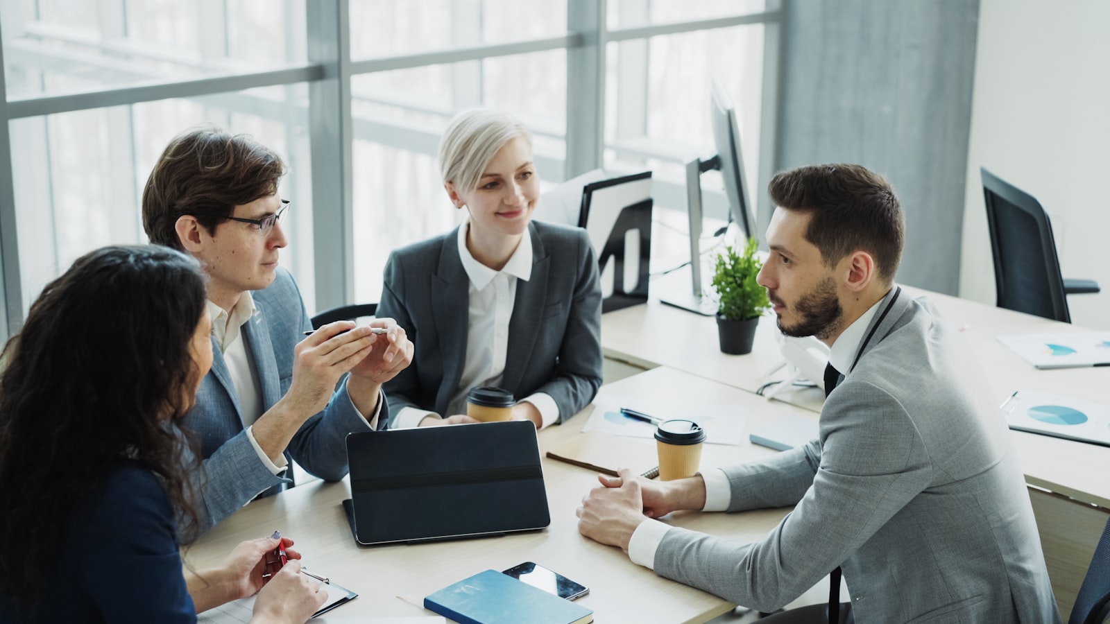 A diverse team of professionals collaborating around a table in a bright, modern office