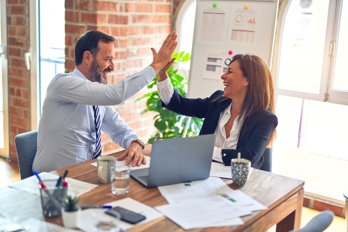 Two professionals celebrating a positive outcome in the office